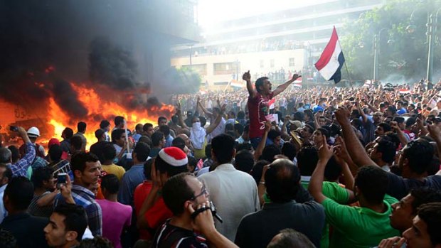 Fanning the flames: Opponents of President Mohammed Mursi protest outside the Muslim Brotherhood headquarters in Alexandria.