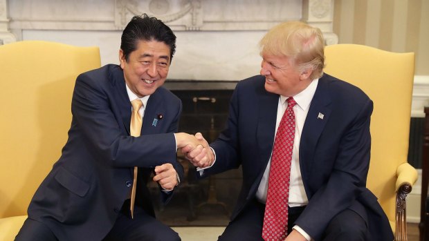 Trump demonstrates his technique with Japanese Prime Minister Shinzo Abe, to the latter's obvious discomfort.