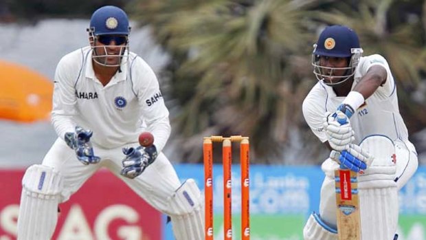 Angelo Mathews in defensive mode as wicketkeeper Mahendra Singh Dhoni watches.