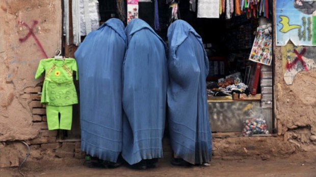 Afghan burqa clad women look in a store in Herat on January 8 ,2013.
