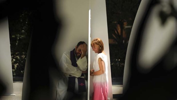 Act of faith ... a woman speaks to a priest at one of the 200 temporary confessionals set up in Madrid's Buen Retiro Park for World Youth Day.