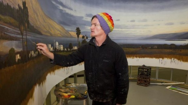 Painting in the round: Alexander McKenzie at work in a Canberra hangar.