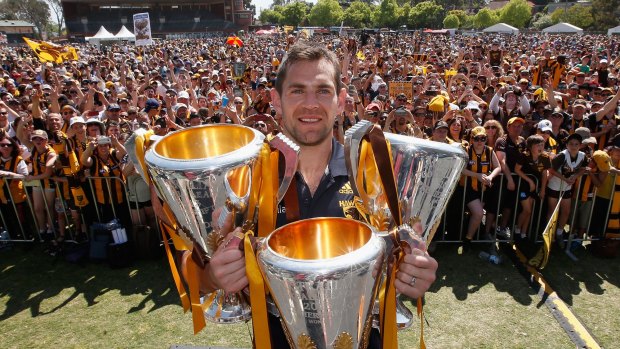 Hawthorn captain Luke Hodge poses with the 2013, 2014 and 2015 premiership trophies.