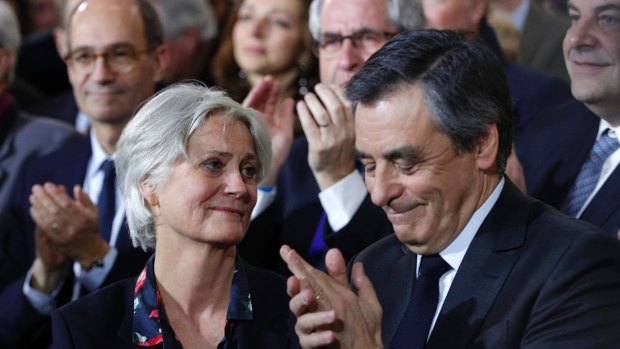 Conservative French presidential candidate Francois Fillon applauds while his wife Penelope looks on.