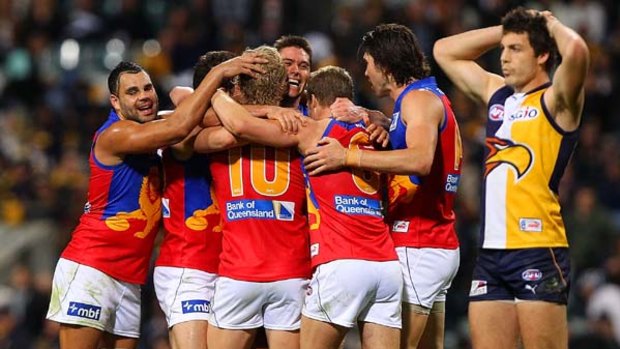 Brisbane Lions players celebrate defeating the Eagles in their bottom-of-ladder clash at Subiaco Oval.