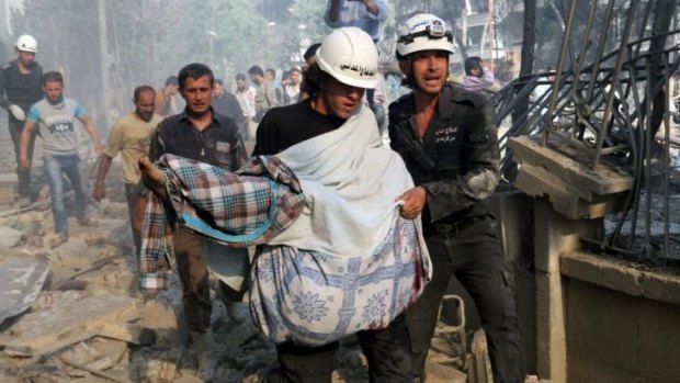 Rescuers carry a body following a reported "barrel bomb" attack by Syrian government forces in the northern city of Aleppo on April 30, 2014. Reports suggest that some barrel bombs contain household chemicals.