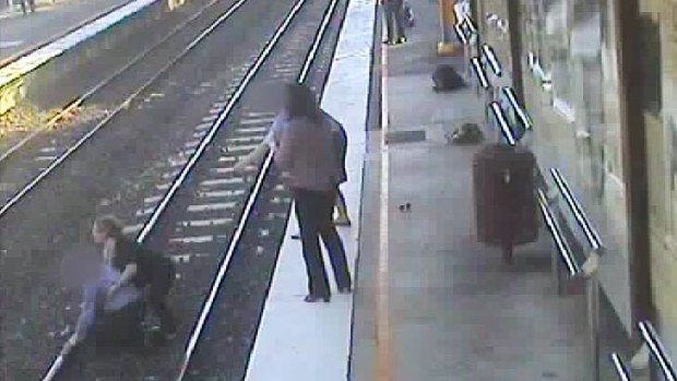 Bystanders pull a man from the tracks at Wooloowin station.
