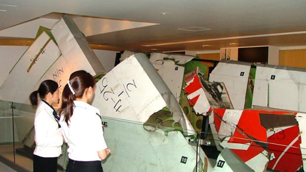 Employees look at the wreckage of a Japan Airlines Boeing 747 that crashed in 1985, on display at the Japan Airlines Safety Promotion Centre in Tokyo.