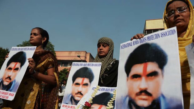 Indian activists pose with pictures of  the Sarabjit Singh in Kolkata on Thursday.