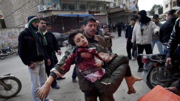 'Massacre' ... a man carries a boy who was severely wounded during heavy fighting.