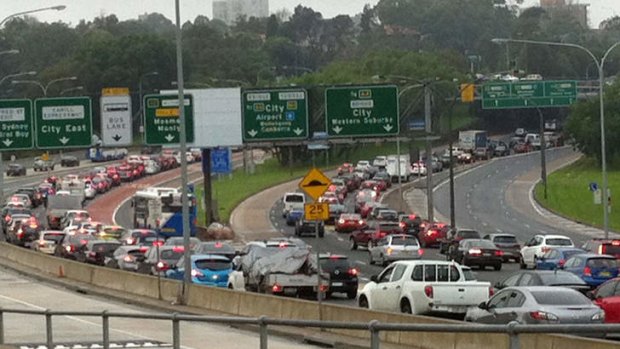 Traffic is backed up 10km after a car overturned in Sydney's Harbour Tunnel.