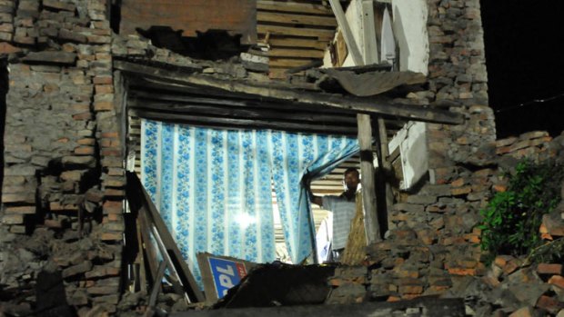 A man looks out a collapsed house, damaged by an earthquake in Bhaktapur.