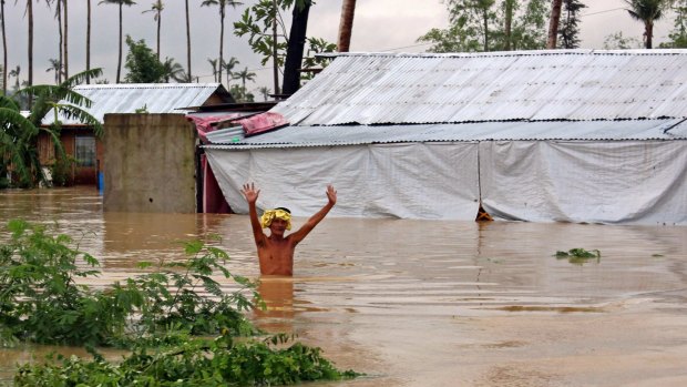 A resident wades through floodwaters brought on by heavy rains from tropical storm Jangmi, locally called Seniang, in Palo town,