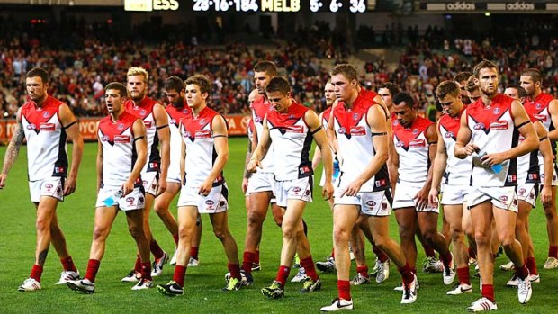 Shell-shocked: Melbourne players leave the MCG after a record belting from Essendon.
