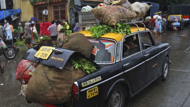 End of the road: A taxi loaded with vegetables drives through a street in Mumbai