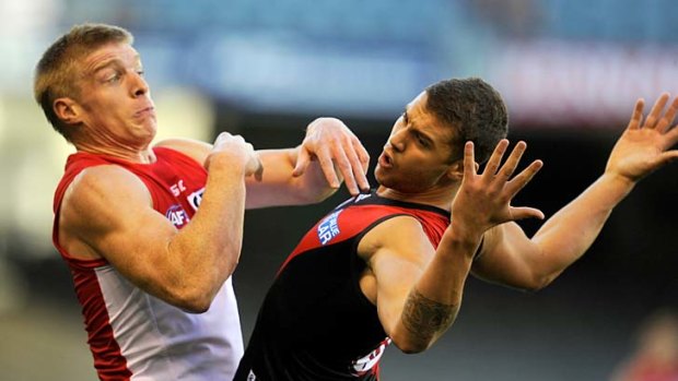 Take that: Sydney's Tommy Walsh (left) and Tayte Pears of Essendon clash during last night's NAB Cup game.