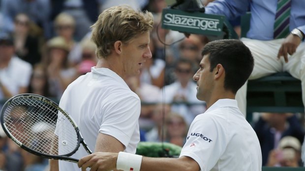 Novak Djokovic shakes hands at the net with Kevin Anderson after winning their singles match.