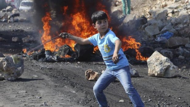 Slingshot: A Palestinian boy throws stones at Israeli soldiers in the West Bank village of Kofr Qadom. 