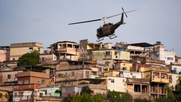  A military police helicopter flies over the Mare favela.