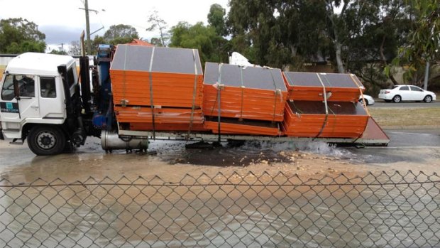 A truck plunged into the road after it collapsed from a burst water main.