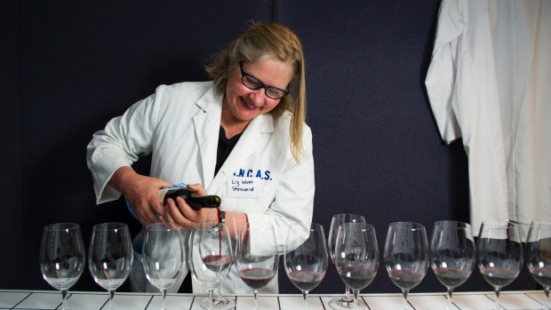 Wine steward Liz Watt sets up for the judging at the Canberra Wine Show. 