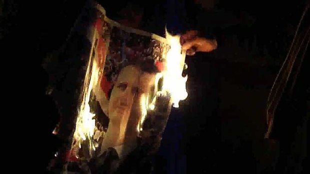 Protesters burn and image of the Syrian leader, President Bashar al-Assad.