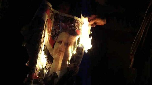 Protesters burn and image of the Syrian leader, President Bashar al-Assad.