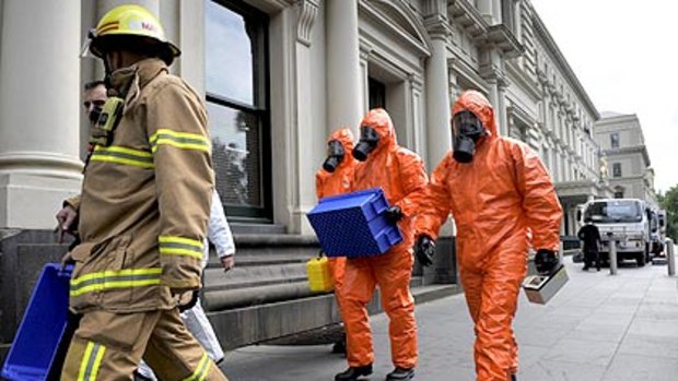 Firemen donned protective suits before inspecting a suspicious package in a Treasury Place mail room this morning.