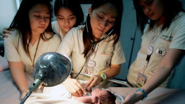 Doctors attend to a baby boy found by aircraft cleaners in a bin on a Gulf Air flight in Manila.