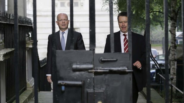 Tough response: Britain's Foreign Secretary William Hague, left, walks with his security officer to Downing Street for a national security meeting in the Cabinet Office.