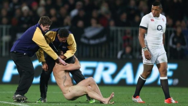 The streaker is manhandled during the All Black Test on Saturday night. The security guard on the right, Brad Hemopo, faces accusations of excessive force.