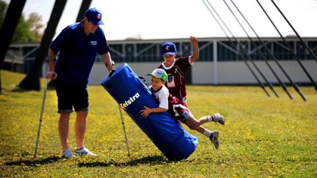 Wish I could do it ... injured Canberra captain Terry Campese watches Queanbeyan Kangaroos junior Matthew Johnston, 6, launch himself at the tackle bag yesterday.