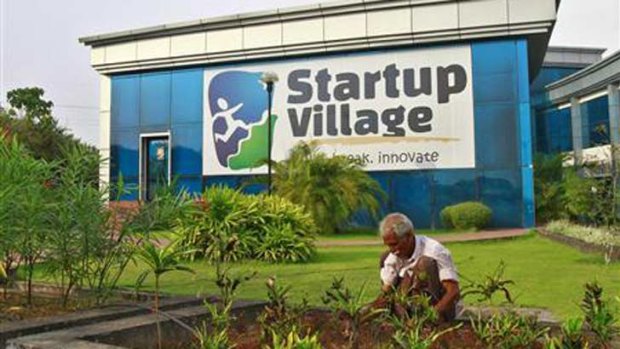 A gardener plants seedlings at the entrance to India's Startup Village.