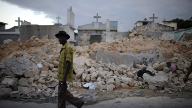 A man walks in front of a destroyed cemetery in Port-au-Prince.