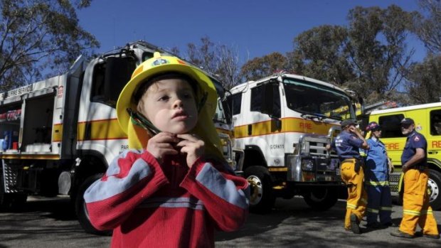 Ingo Wolf, 4, at the bushfire season launch. Behind him are two new ACT Rural Fire Service appliances, handed over at the ceremony.