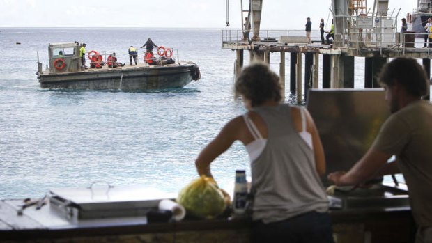 Locals at Flying Fish Cove have a ringside seat as asylum seekers are taken ashore at Christmas Island.