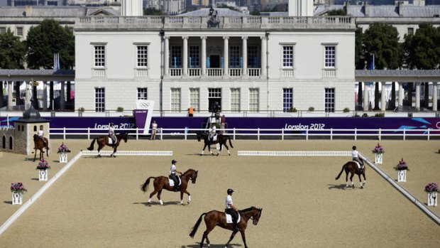 Riders and their horses train for the equestrian eventing competition in front of the Queen's House, a former royal residence built in Greenwich Park between 1616 and 1619.