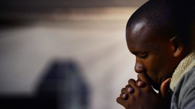 Sacred space: A man prays during a memorial ceremony for Nelson Mandela.