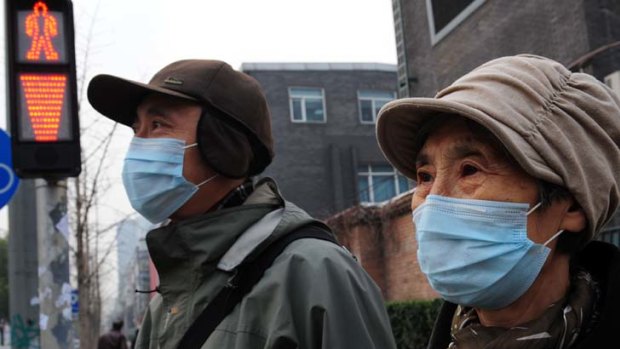 An elderly couple wears masks as protection against air pollution in Beijing.