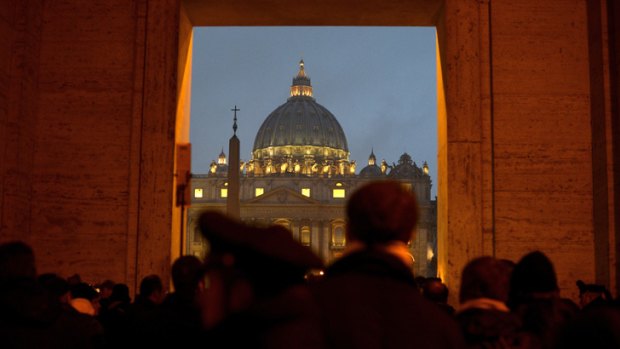 People gather in front of Saint Peter's dome at the Vatican on February 11, 2013 after Pope Benedict XVI announced he will resign as leader of the world's 1.1 billion Catholics.