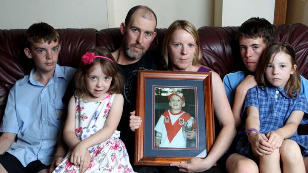 The Crouch family: From left Jack, 13, Amelia, 5, Peter and Carmel, Makayla, 7 and Ben, 14, with a picture of Adam.