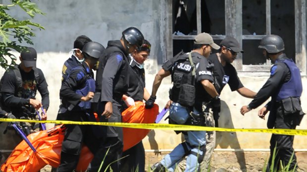 Elite Indonesian police commandos carry a body bag out of a house in Central Java.