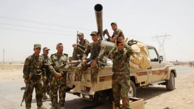 Members of the Kurdish security forces pose take part in an intensive security deployment on the outskirts of Kirkuk.