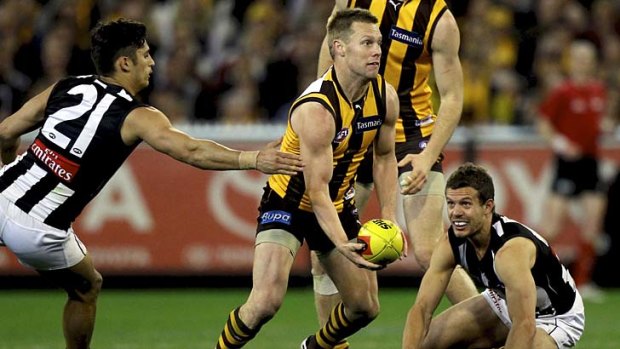 In traffic: Sam Mitchell gets through two Magpies.