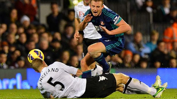 Slide tackle ... Fulham defender Brede Hangeland tackles Sunderland's Lee Cattermole.