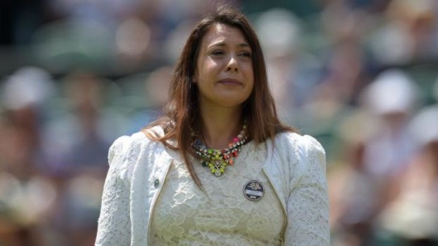 Last year's champion Marion Bartoli takes part in a ceremonial coin-toss in honour of Britain's Elena Baltacha, who recently died of cancer.