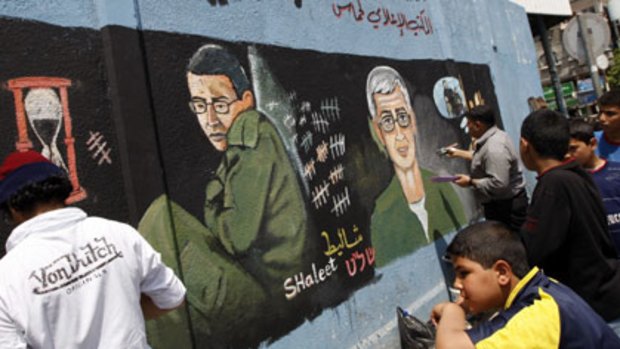 Art of the threat...Palestinians paint a mural in Jabaliya in the Gaza Strip  showing Gilad Schalit, the  Israeli soldier captured in 2006,  ageing in captivity.