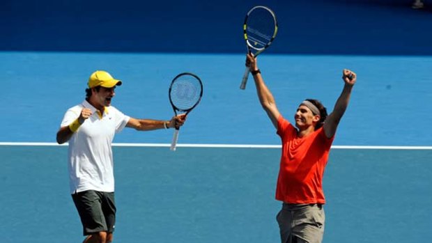 Temporary truce ... Roger Federer and Rafael Nadal play on the same side in Melbourne yesterday to raise money for flood victims.