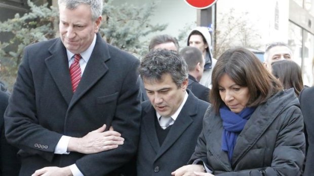 New York city mayor Bill de Blasio, left, Paris mayor Anne Hidalgo, right, and Patrick Pelloux, centre, a staff member of <i>Charlie Hebdo</i> newspaper, outside <i>Charlie Hebdo</i> offices, in Paris, on January 20.