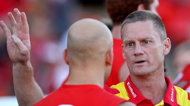 Listen up: Gold Coast coach Guy McKenna makes a point to star Gary Ablett at three-quarter-time yesterday.